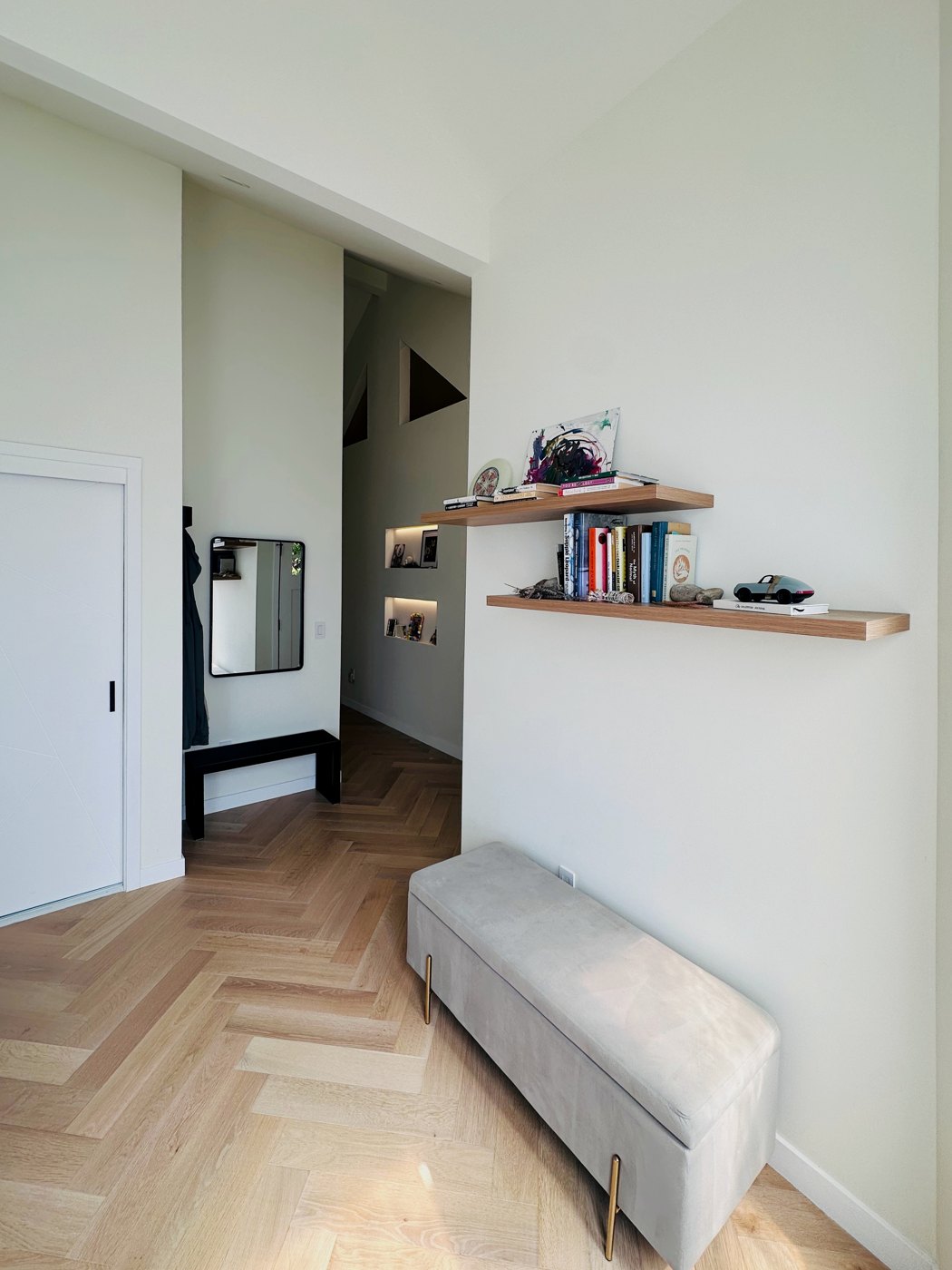 The front room, with oak shelves, a bench, and the herringbone oak floor