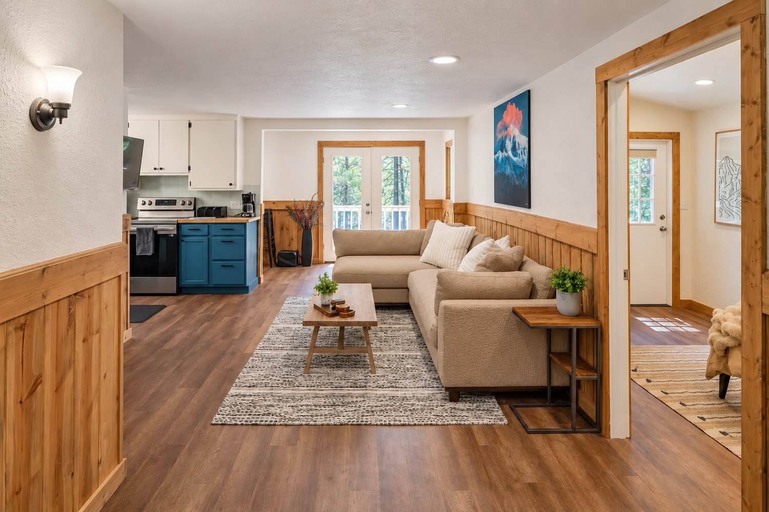 The main living space at Residence 04 in Long Barn, with pine wainscot and a deep-blue kitchen