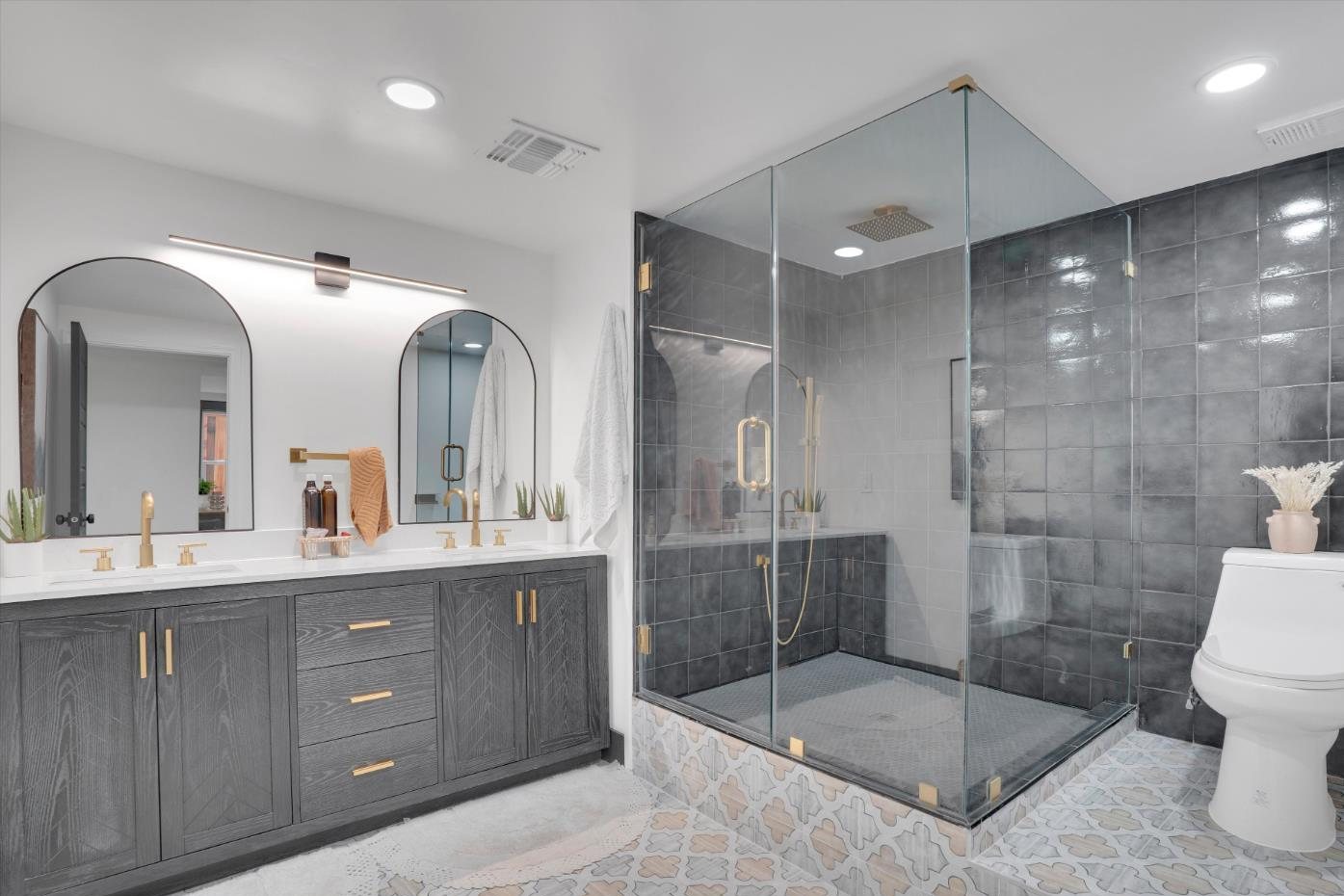 The lower-level bath after, black-themed with a glass shower