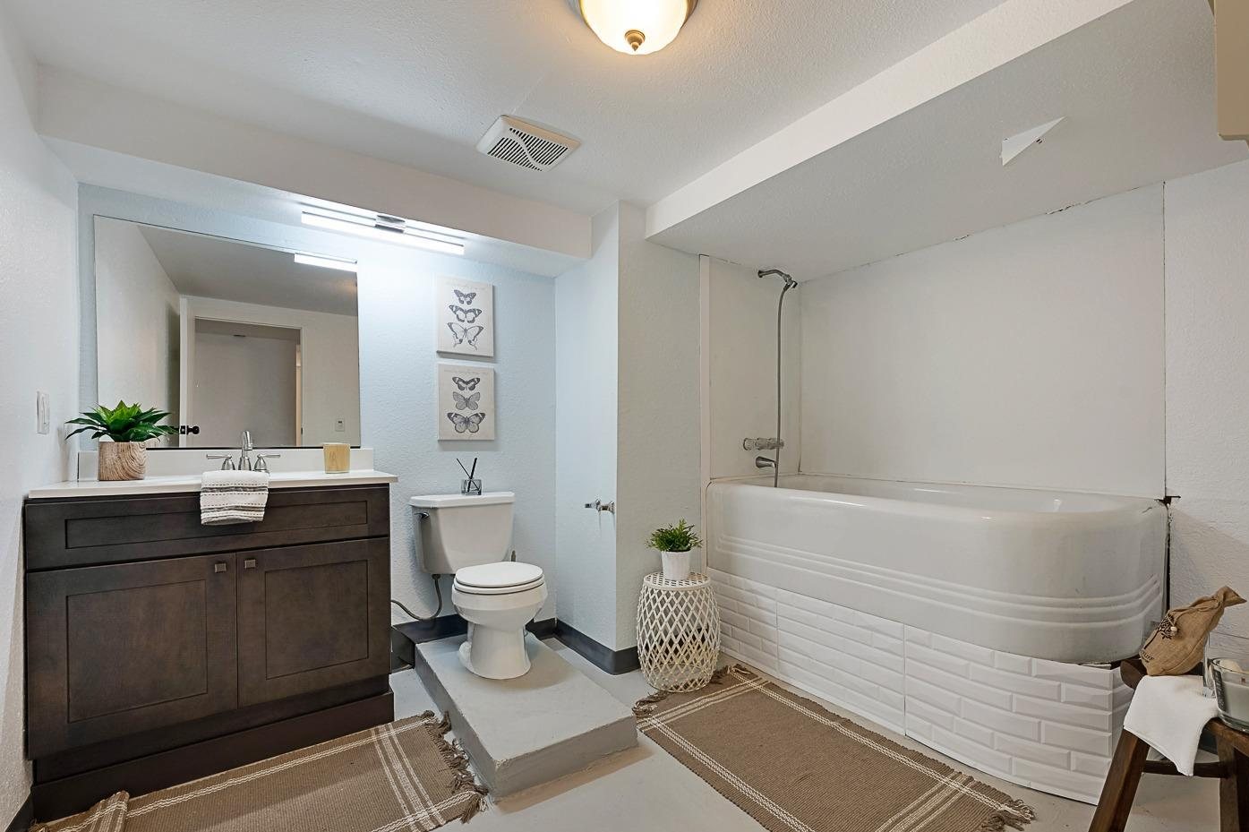 The lower-level bath before, with a raised tub