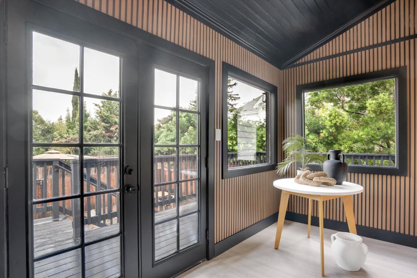 Slatted wood paneling and black French doors